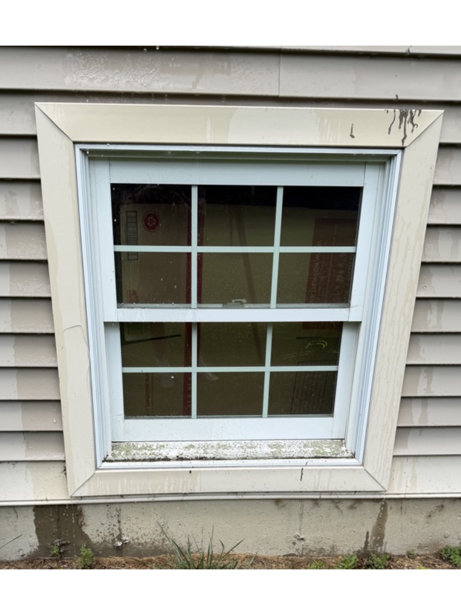 Window before cleaning — mildewed sill and water-spotted frame