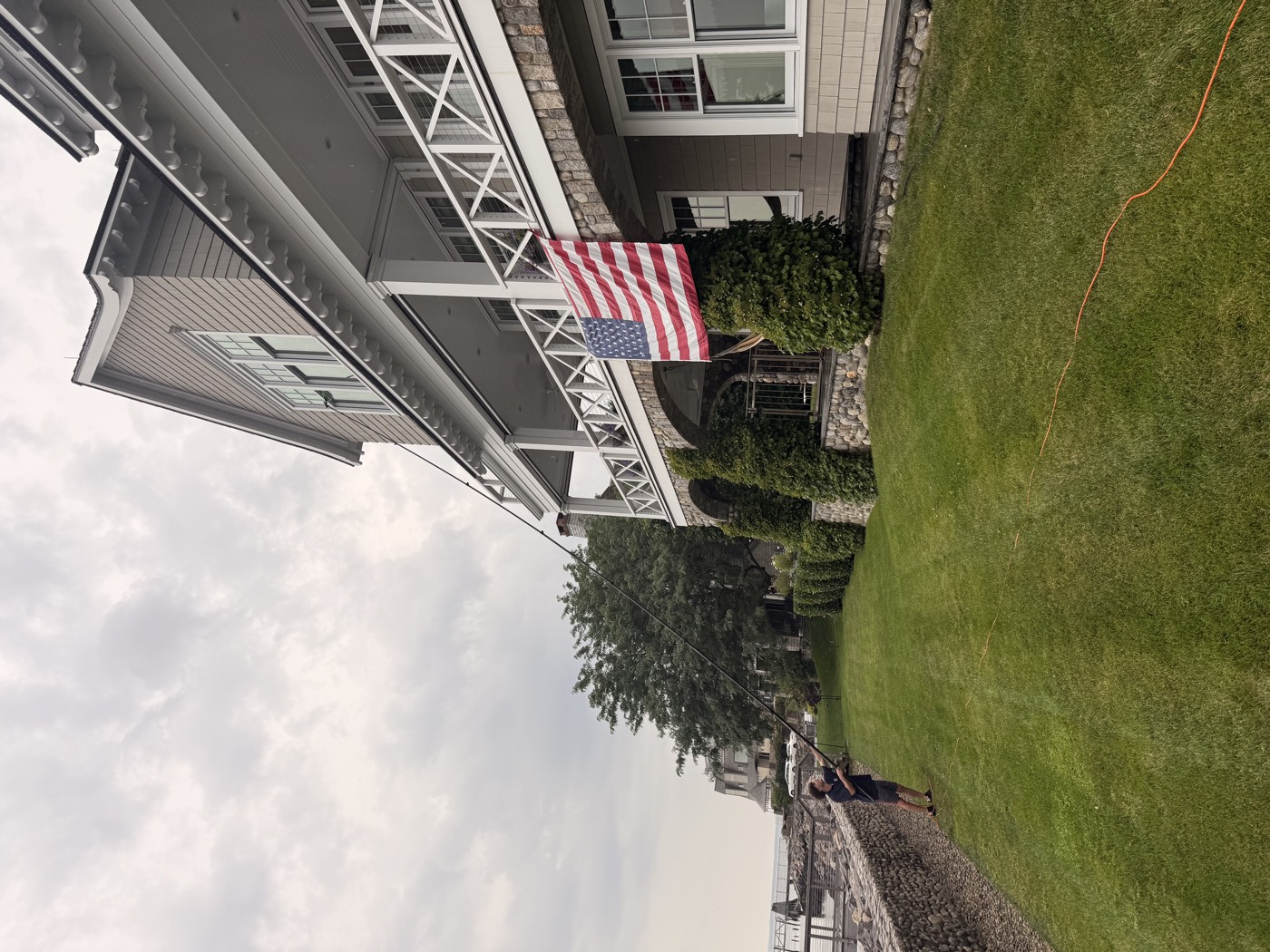 Clear View technician pole-cleaning the upper windows of a waterfront Connecticut home with a wraparound porch