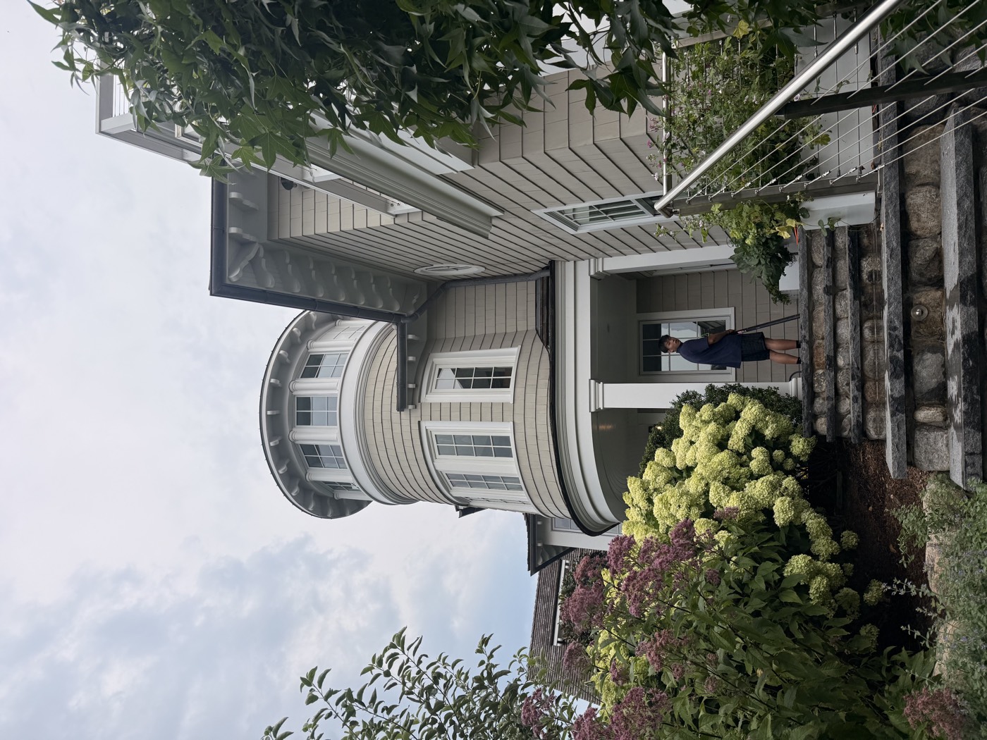 Clear View technician on the stone steps of a Connecticut home with a rounded turret entry