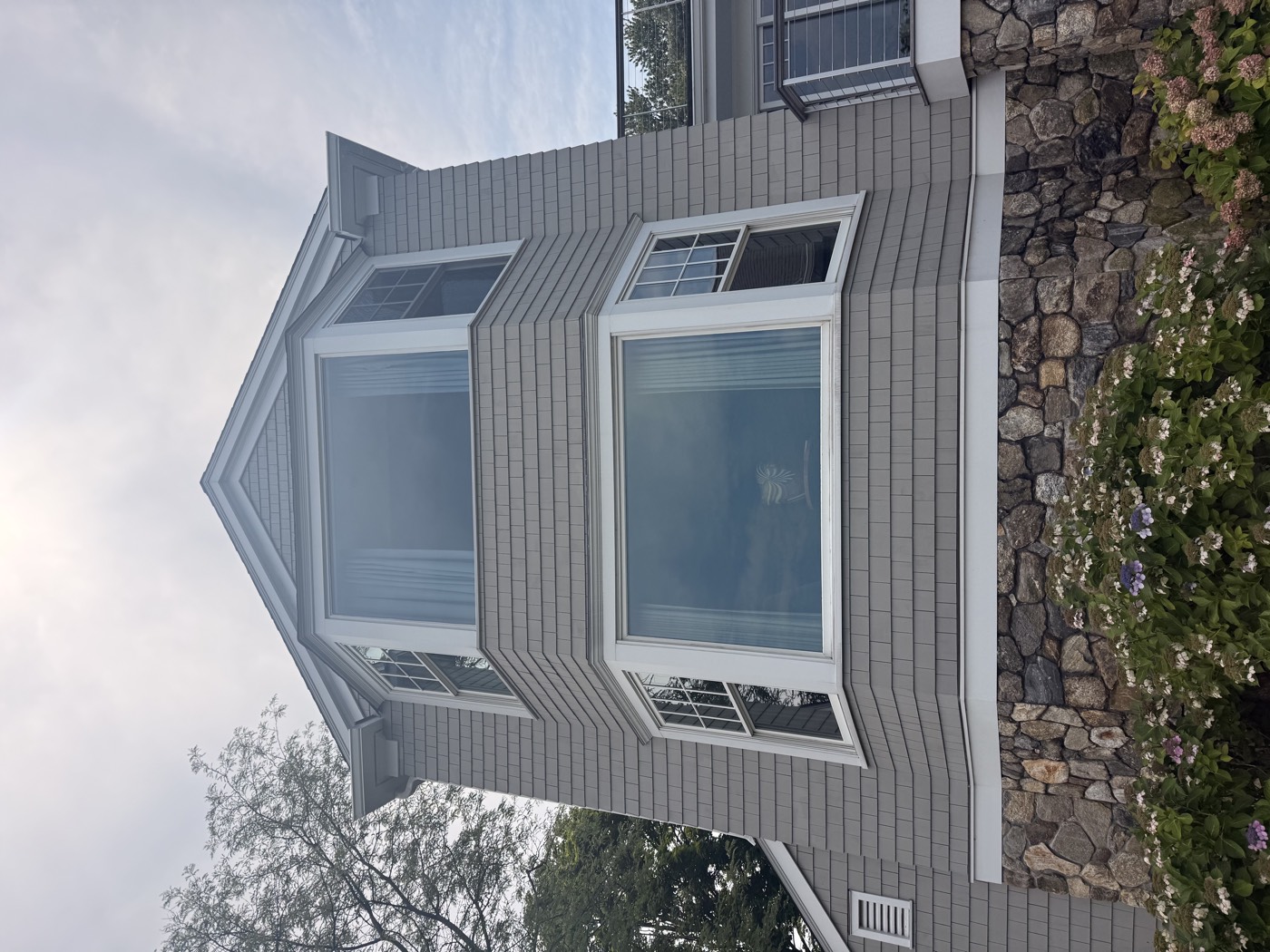 Bay window tower on a gray shingle Connecticut home with spotless glass, cleaned by Clear View