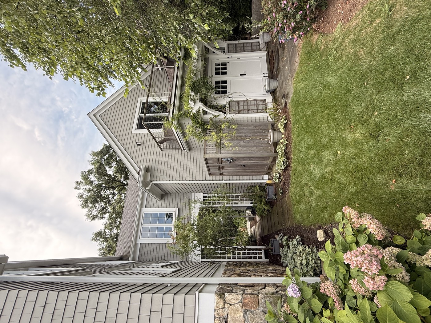 Courtyard and garage of a Connecticut shingle home framed by hydrangeas, windows cleaned by Clear View
