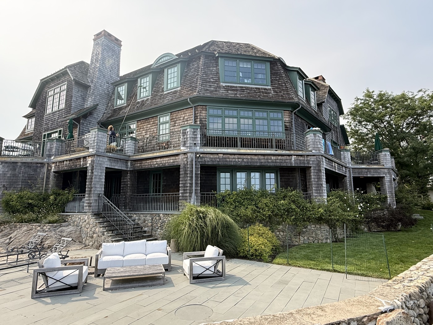 Full rear elevation of a cedar-shingle Connecticut estate with freshly cleaned windows by Clear View