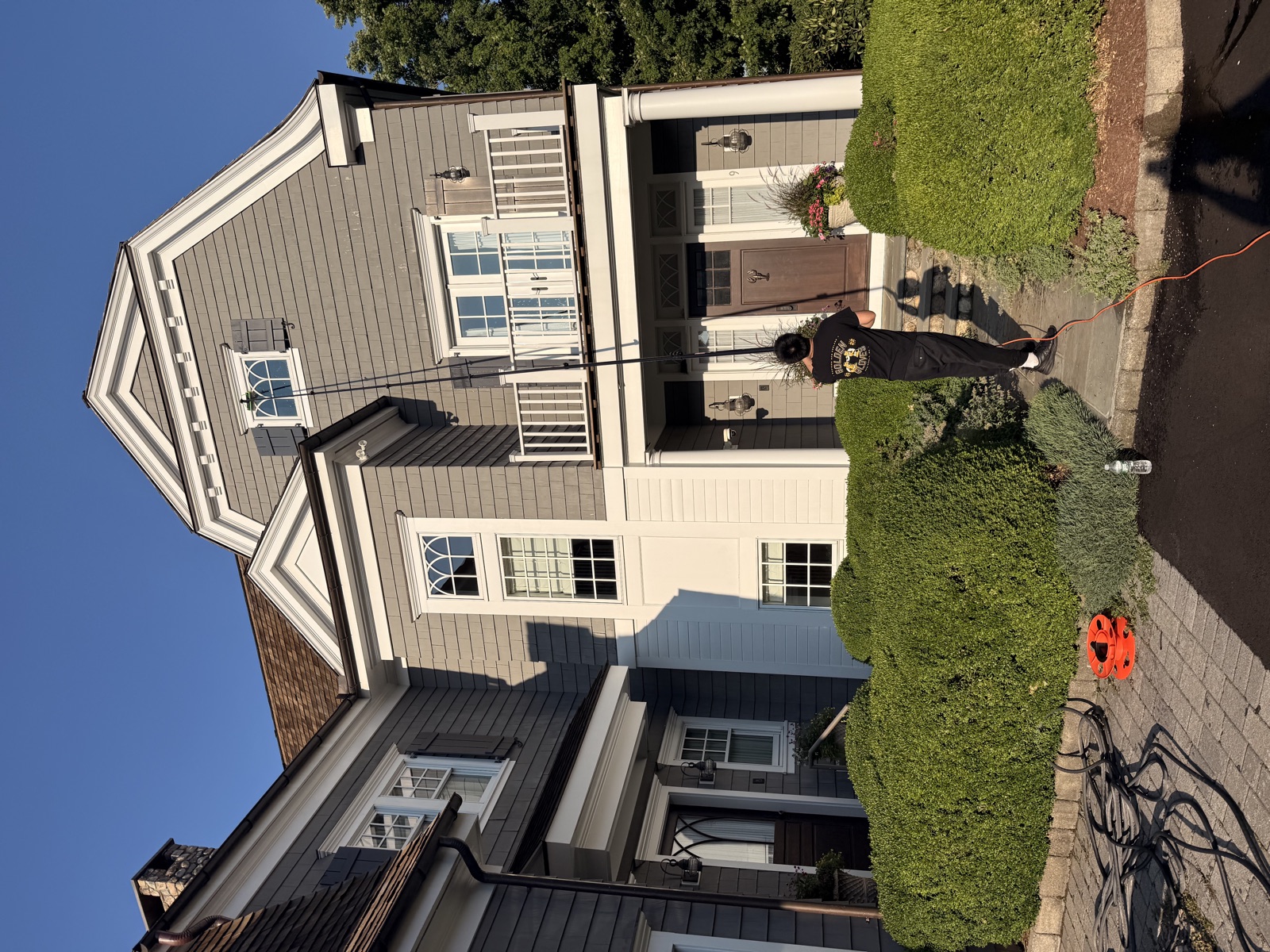 Clear View crew pole-cleaning a gray shingle home with balcony, Connecticut