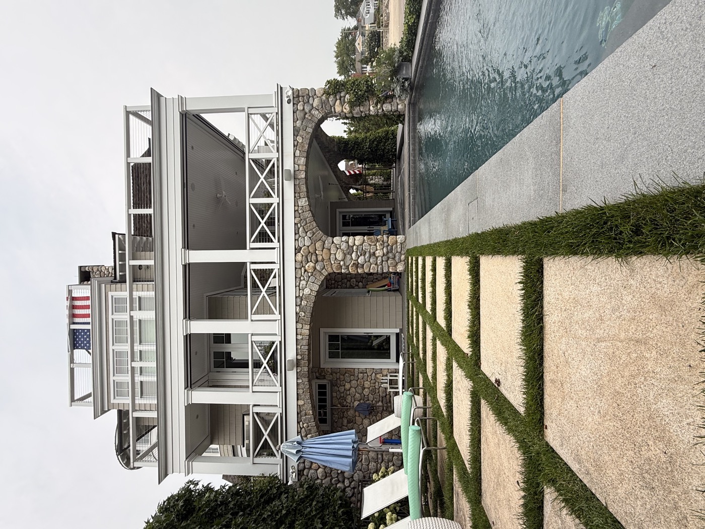 Poolside stone archways and balconies of a Connecticut shoreline home cleaned by Clear View
