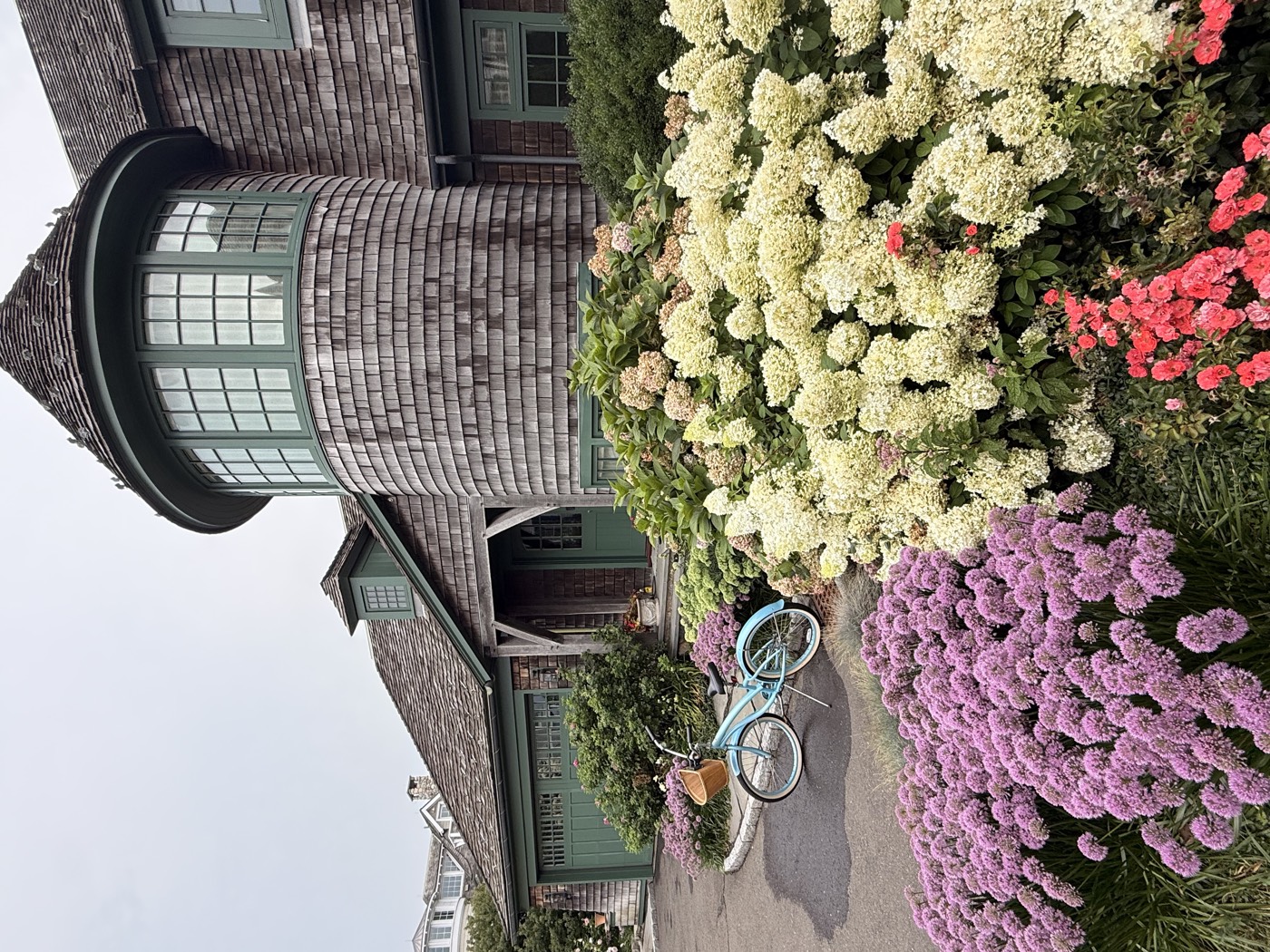 Cedar-shingle Connecticut estate with a turret and hydrangea beds, windows cleaned by Clear View