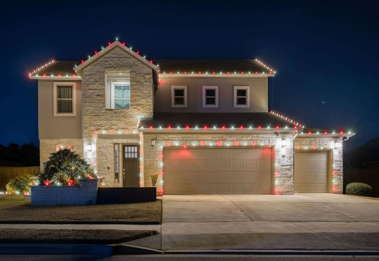 Example of red and white roofline lighting on a stone home