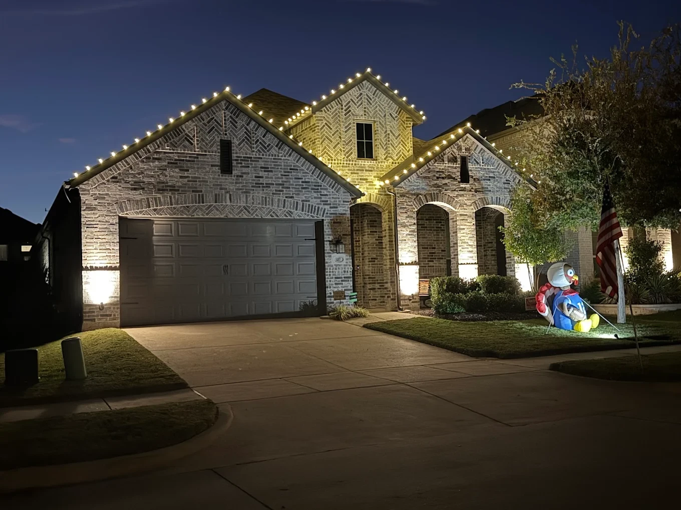 Example of warm-white roofline lighting with holiday yard decor