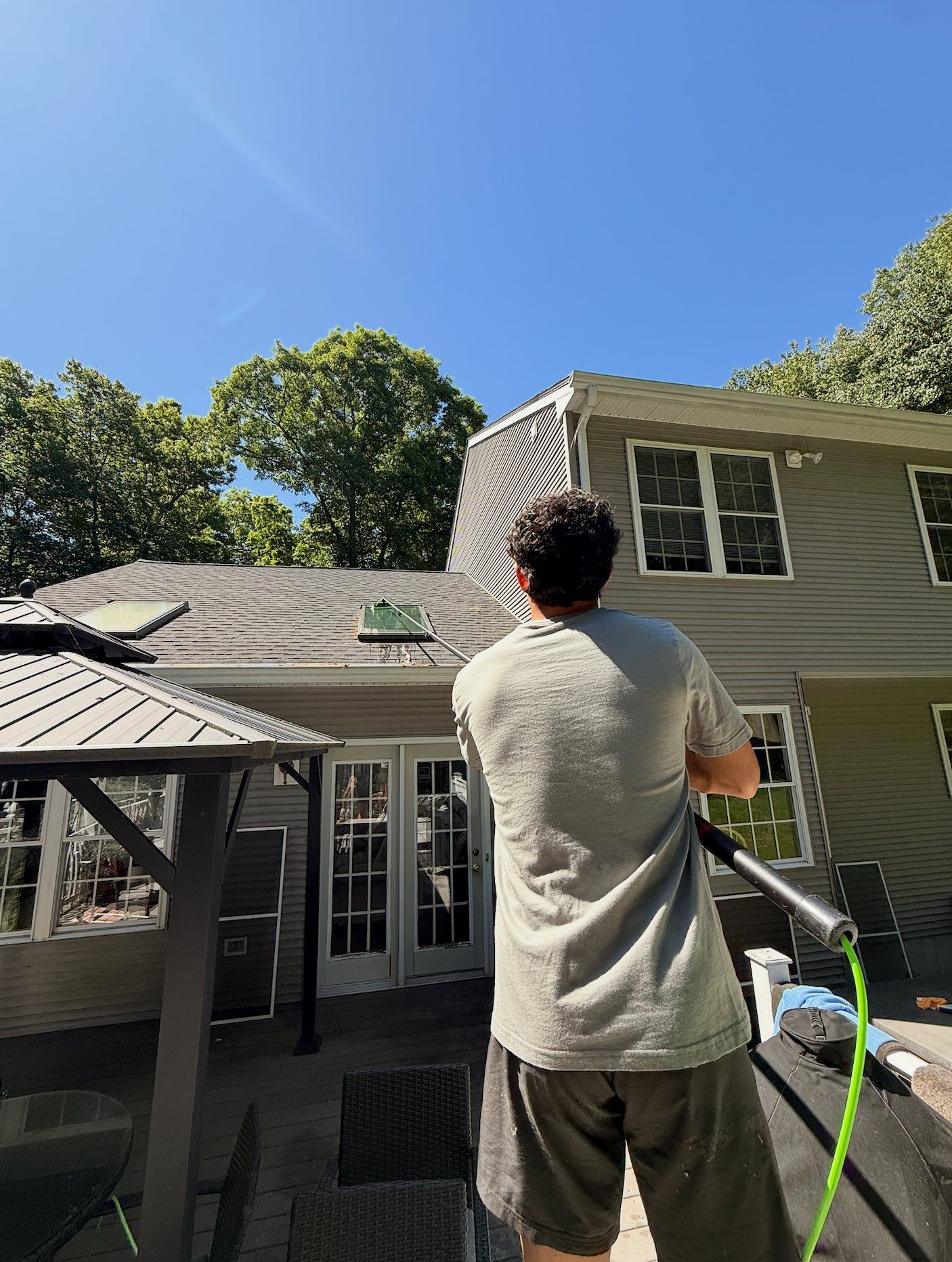 Clear View technician cleaning windows at a New England home